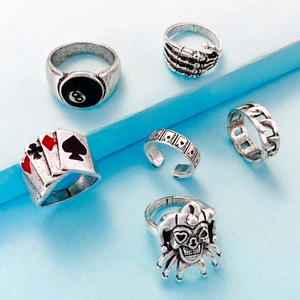 Detail of 6-piece gothic punk ring set with skull and billiard elements on blue stand