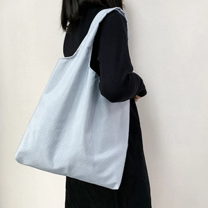 Detail of light blue polka dot tote bag showing large capacity and soft canvas material