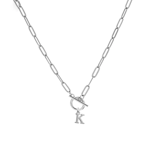 Detailed close-up of silver paperclip chain necklace with T-bar closure and letter K pendant