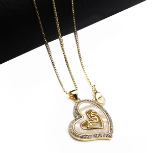 Detailed close-up of a gold heart MOM pendant with white shell and inlaid zircons