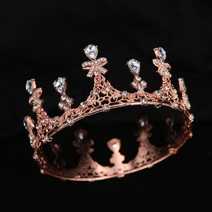 Detailed close-up of a rose gold bridal tiara with sparkling crystal bow and teardrop accents