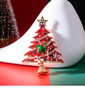 Macro detail of enamel Christmas tree brooch with colorful rhinestones on gold base