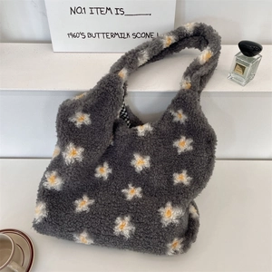 Détail d'un sac cabas en peluche grise avec fleurs et doublure à carreaux