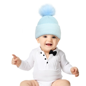 Detail of light blue knitted baby beanie with soft ribbed texture and large faux fur pom-pom