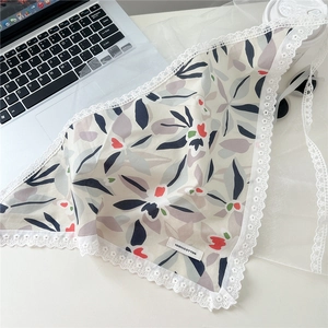 Detailed view of beige floral cotton scarf with lace trim and 100% cotton label