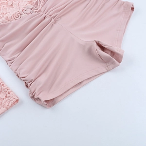 Detail of pink lace stitching and elastic fabric texture on a long sleeve jumpsuit