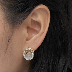 Detail of star and moon gold earring with opal stone and crystals on ear