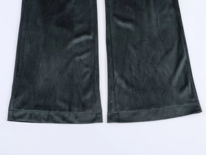 Détail montrant la texture en velours et le bas évasé du pantalon noir élégant