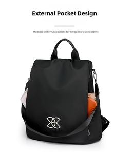 Detail view of the side pocket on a black waterproof backpack with an orange wallet inside