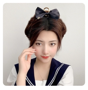 Detail of elegant black satin bow hair claw clip worn on a sophisticated updo hairstyle