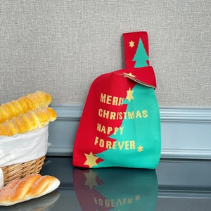 Détail d'un sac à main en tricot de Noël avec motifs festifs rouges et verts