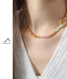 Close-up of handmade stainless steel necklace with colorful amazonite beads on neck