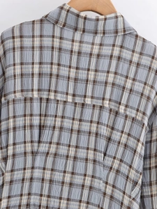 Detailansicht der blau-braunen Karostoff-Textur an einem langärmligen Hemdblusenkleid
