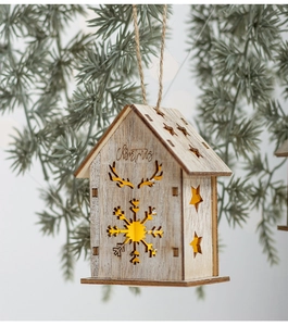 Dettaglio casetta di Natale in legno con luce LED calda e incisioni decorative a laser