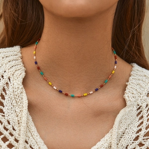 Handmade bohemian choker with colorful cube beads and tiny gold accents on a model