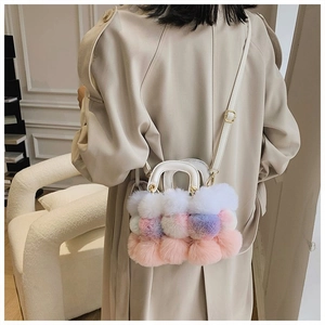 Close-up of colorful plush faux fur handbag with pink and purple tones on beige coat