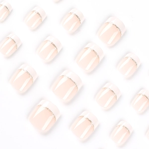 Short French tip press-on nails with white edges and delicate gold glitter line accents