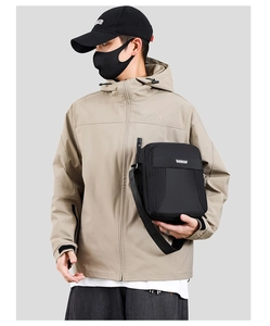 Detail of waterproof nylon crossbody bag featuring multiple zipper layers and adjustable strap