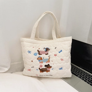 Close-up of heart quilted white tote bag featuring embroidered dachshund dogs and patterns