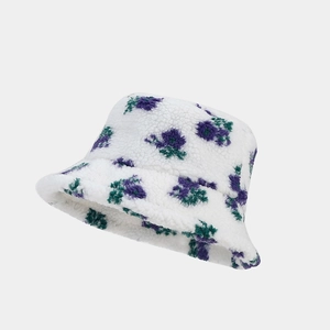 Gros plan d'un chapeau bob fleuri en polaire blanche avec des motifs violets et verts