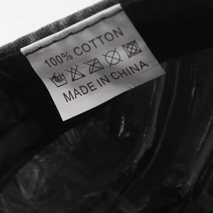 Macro view of care label for washed cotton baseball cap showing 100% cotton and wash icons