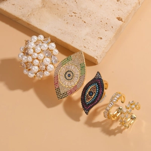 Detail shot of five gold rings with pearls, cubic zirconia, and evil eye motifs