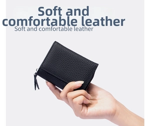 Close-up of black lychee grain leather mini wallet with zipper closure held in hand