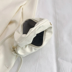 White ruched crescent handbag with gold hardware shown open from a top-down view