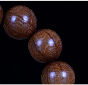 Macro shot of high-quality wood prayer beads with natural flame-like grain patterns