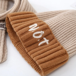Detail of color-block knit hat and scarf set featuring NOT embroidery and soft texture