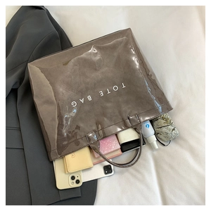 Macro view of spacious dark grey tote bag interior showing daily items and phone