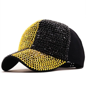 Detail view of sparkly black and gold rhinestones on a baseball cap with adjustable strap