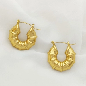 Fashionable gold U-shaped hoop earrings with vintage spiral texture on white fabric