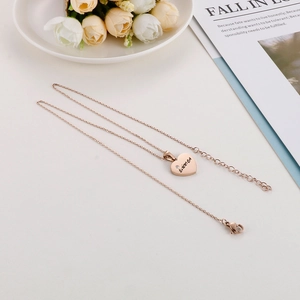 Detail of rose gold heart pendant necklace with E.M.M.A engraving and lobster clasp