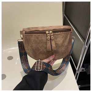 Détail du sac bandoulière marron avec large sangle à motifs bohèmes de style vintage