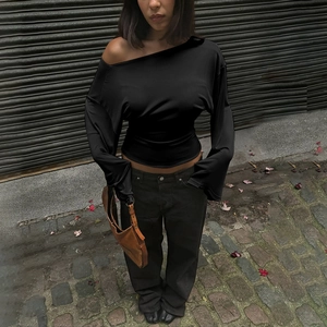 Detail view of a black off-shoulder long sleeve slim fit top for women in outdoor setting