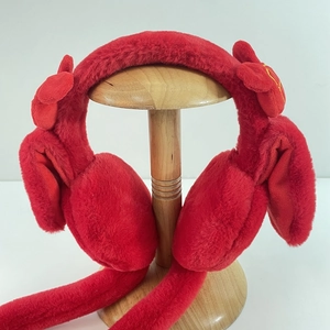 Close-up of red plush earmuffs with festive yellow embroidery on long animal ears