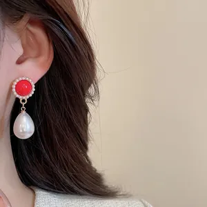 Gros plan de boucles d'oreilles cœur rouge élégantes avec perles et pendentifs