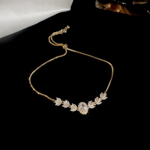 Detailed macro view of gold plated bolo bracelet with marquise cut zircon flower charm