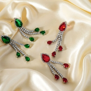 Detail of luxury long tassel earrings with pear-cut emerald and ruby zircon stones
