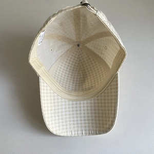 Inside view of beige gingham check baseball cap with cotton sweatband and metal buckle