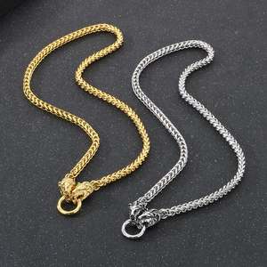Detail of vintage punk gold and silver dragon bone chains with twin lion head clasps