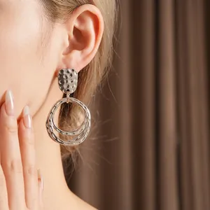 Silver hammered texture layered hoop earrings on model with modern geometric design