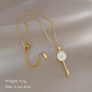 Gold stainless steel key necklace featuring a white shell inlay and sparkling crystals