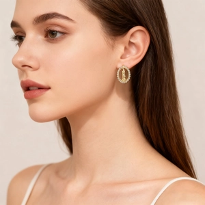 Golden oval religious stud earrings with zircon inlay and relief on female model