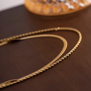 Elegant gold flat snake chain and twisted rope necklace layered for a trendy look