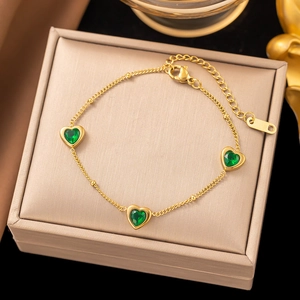 Detail of gold chain bracelet with three green heart gemstones and lobster clasp