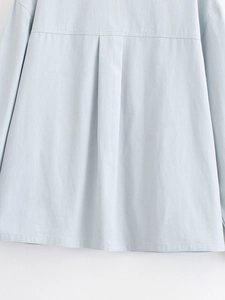 Detail shot of light blue casual shirt featuring a precise back inverted pleat design