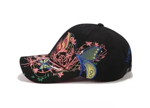 Vista laterale del cappello nero con ricami floreali e farfalle colorate
