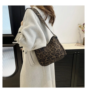 Leopard print crossbody bag worn over a white coat for a stylish winter commute
